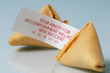 Open fortune cookie with fortune sticking out