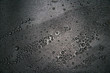 Small drops of water on a dark teflon surface.
