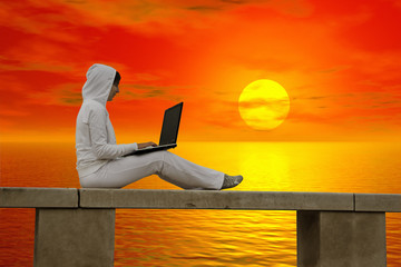 Canvas Print - woman working with is laptop at the sunset