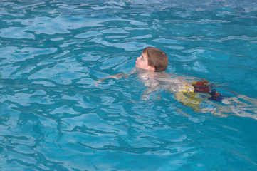  A little boy swimming in a pool.