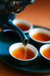 Pouring fresh tea to elegant china teacups. 