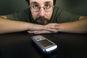 man waiting for a call while the mobile is in the table