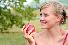 Young Woman Holding Apple, Smiling