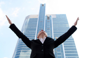 Businesswoman Raising Arms at Skyscraper