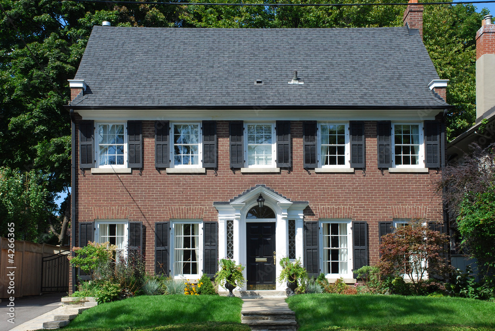 Two storey red brick house with black shutters Stock Photo | Adobe Stock