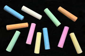 Wall Mural - Colorful large chalk sticks on a blackboard.