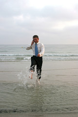 Businessman walking at the beach during cloudy weather. 