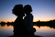 The Silhouette Of Mother With The Child On Sunset
