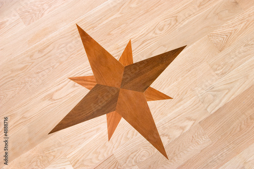 Fotografija compass rose inlaid in wood, background