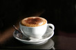 © Angus - A cappuccino in a cup on a black table