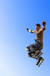 © Denis Babenko - Roller boy jumping from parapet on the blue sky