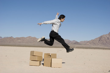 Wall Mural - Businesman jumping over boxes