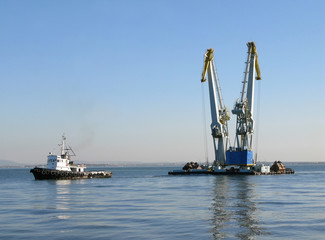 Large maritime cranes towed by boat