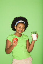 African American Girl Holding Glass Of Milk And Apple.