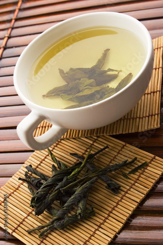 Naklejka na szybę Green tea in a white cup with a tea leafs