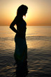 © shime - Woman silhouette on the beach at sunrise