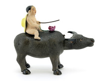 Figurine Of Small Boy On The Bull On White Backgrounds