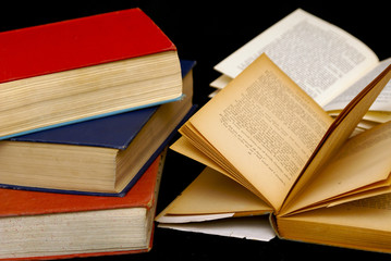 stack of three old books  two others with their pages open 