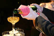 Holding A Bottle Of Champagne Pouring Into A Cascade Glass