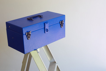 Blue workers construction tool box on ladder