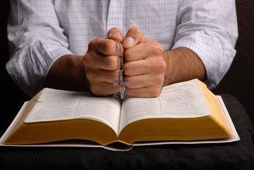 holy bible open with a cross on a hand