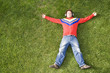 a young man lay down on the grass enjoying good music 