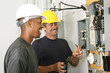Two electricians working on an electrical panel 