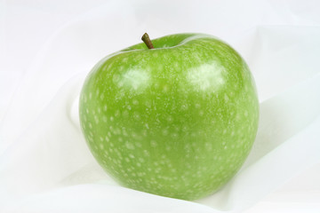 Green, healthy, organic apple on a textile background