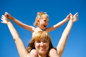 Mother and son on a background of the blue sky.Wind