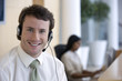 © carlosseller - Young businessman with headset in office