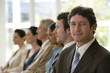 © carlosseller - Confident businessman with team seated in line with him
