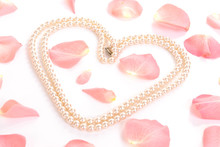 Heart Shaped From String Of Pearls Among Pink Rose Petals