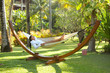 © Dash - Woman relaxing on hammock at exotic surrounding