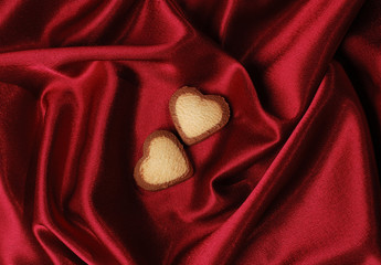 Wall Mural - sweet hearts on red silk background