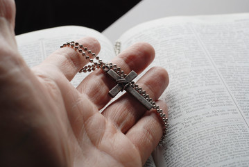 Wall Mural - holy bible open with a cross on a hand