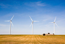 Three Wind Turbines On A Field. Spain
