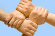 © pressmaster - Image of crossed hands isolated over blue background