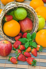 Poster - a wooden basket withfresh fruits and green mint leaves