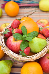 Canvas Print - a wooden basket withfresh fruits and green mint leaves