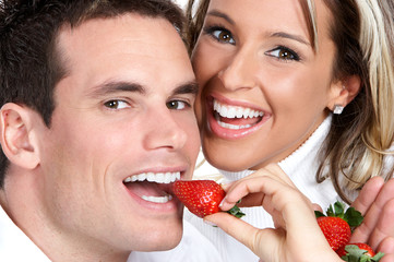 Wall Mural - young love couple eating strawberries. over white background .