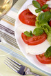 A fresh caprese salad with a glass of white wine