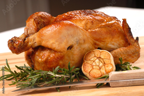 Fotografie, Obraz Whole roasted chicken with garlic, rosemary and carving knife