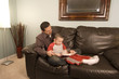 © Mehmet Dilsiz - Father is reading a book to his hyper son moving around