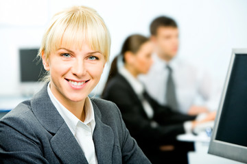 Canvas Print - Portrait of beautiful businesswoman sitting near computer 