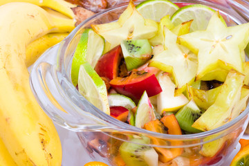 Wall Mural - Glass bowl of salad with exotic fruits, low DOF