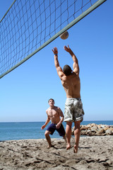 Wall Mural - Young men playing volleyball on the beach