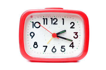 Old red alarm clock on a white background