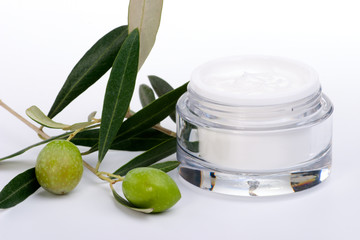 ar of moisturizing face cream and twig with green olives..