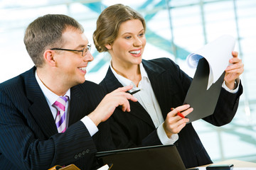 Wall Mural - Portrait of two businesspeople doing together paperwork 