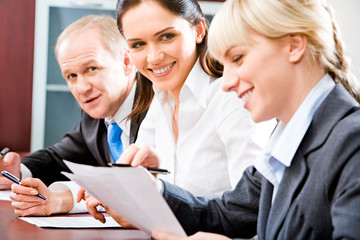 Canvas Print - Portrait of smiling businesswomen working with documents 